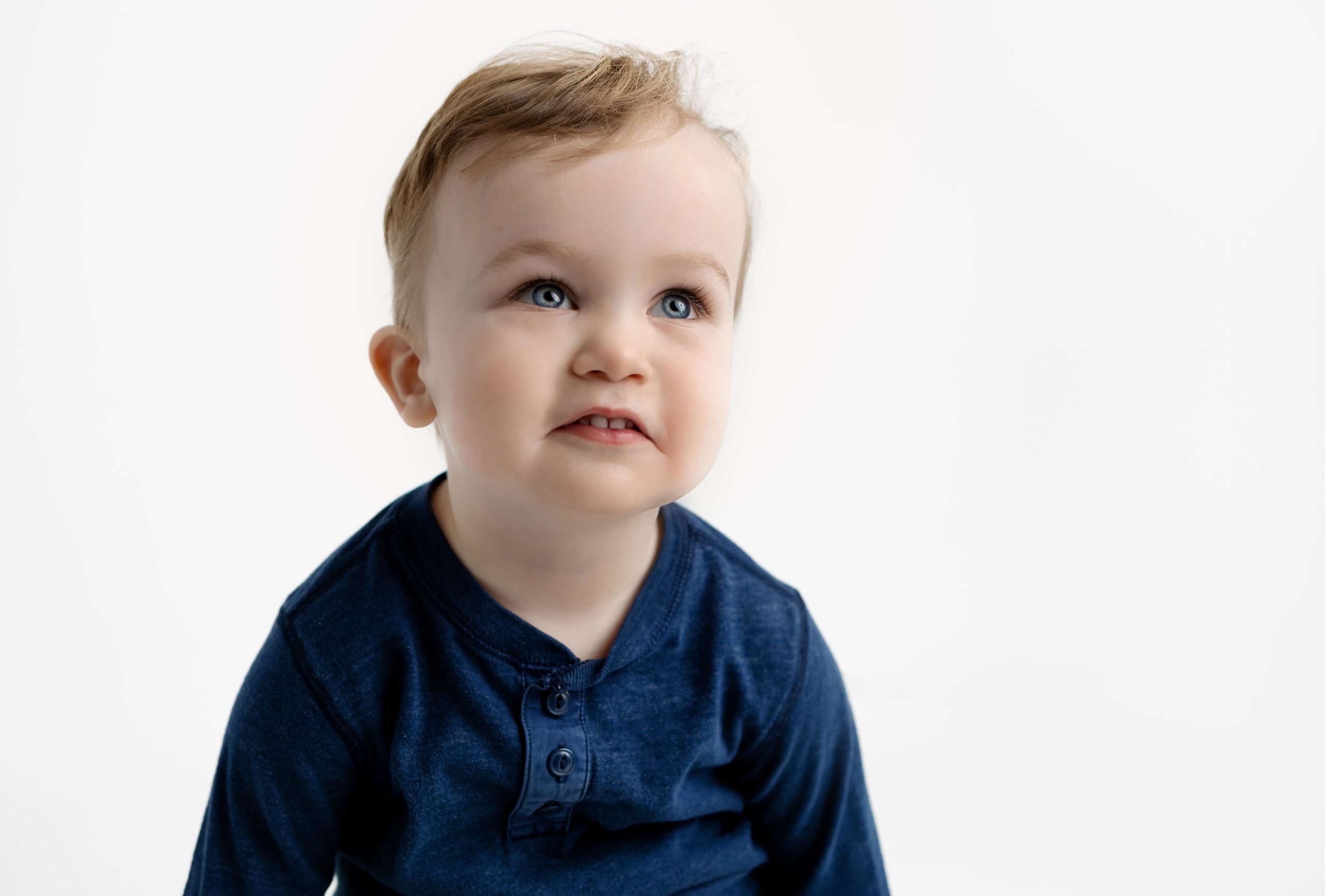 Little boy in blue shirt staring off by Dallas Children Photographer