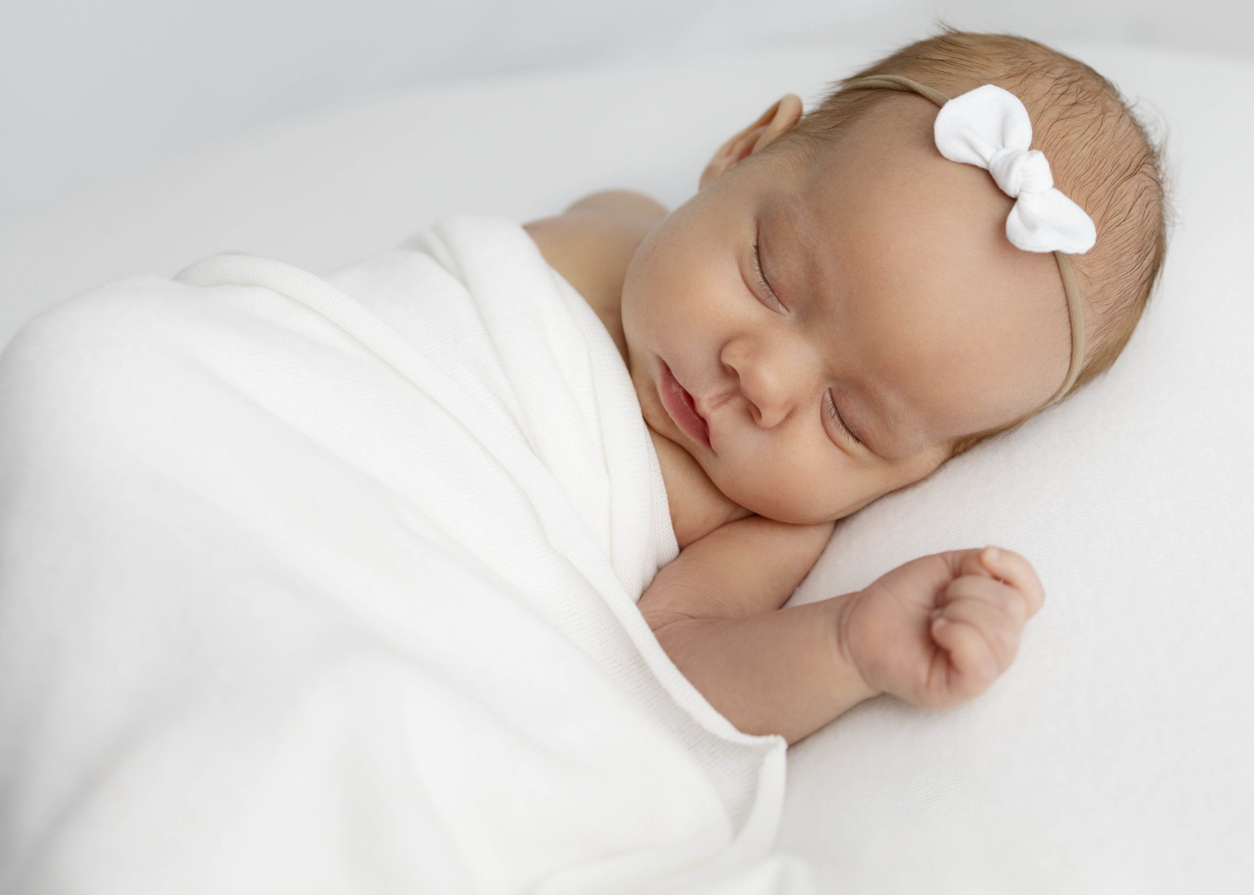 Newborn baby girl sleeping with arm extended