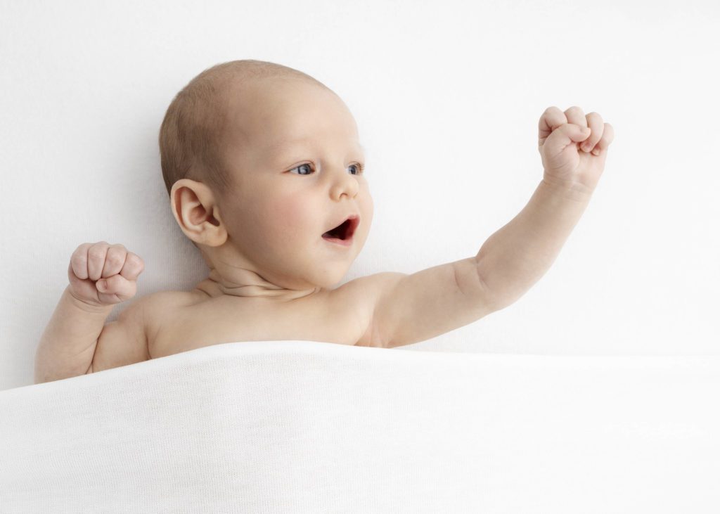 Newborn raising arm in the air