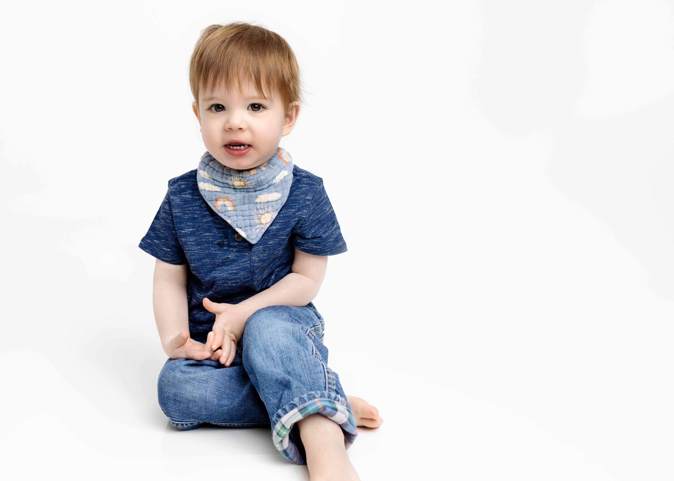 Little boy sitting with jeans and a blue shirt