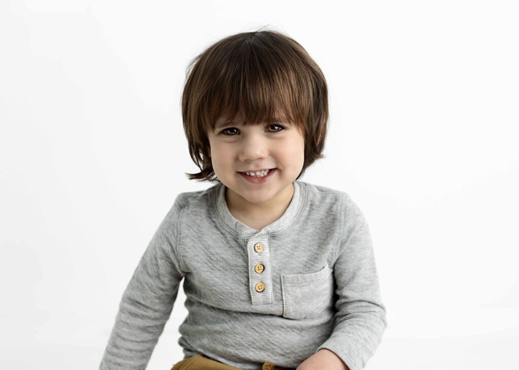Toddler boy smiling at camera by Dallas portrait photography