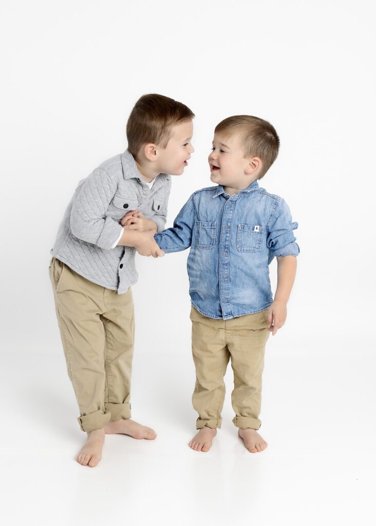 Toddler brothers laughing with one another by Dallas portrait photography