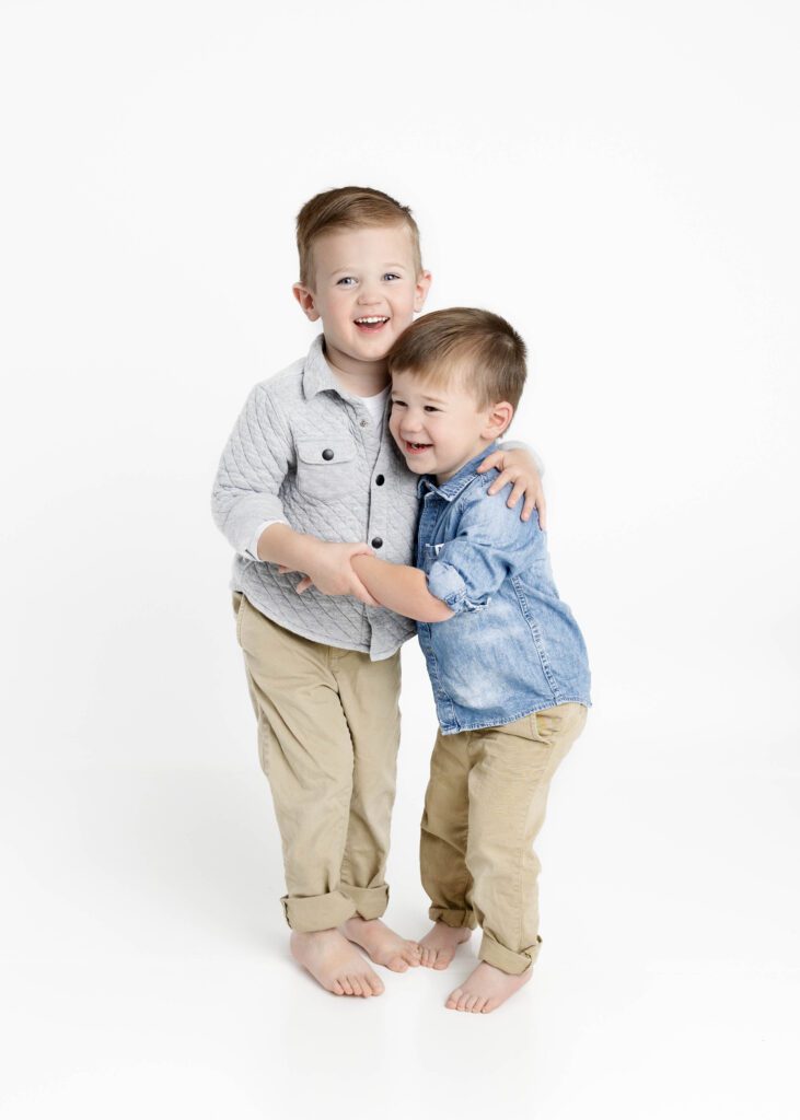 Toddler brothers holding and laughing with one another