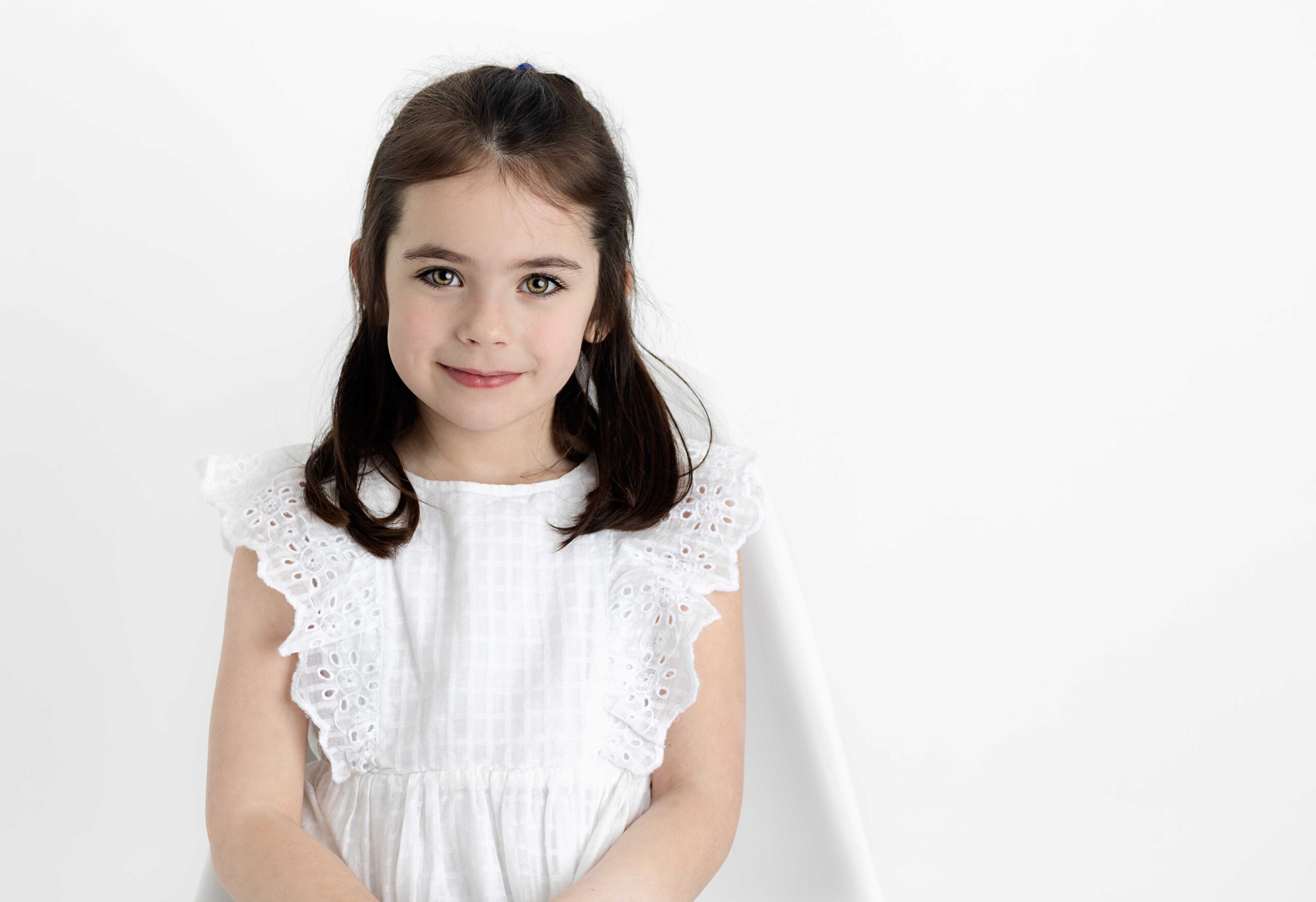 Little girl in white dress by photography studio Dallas TX