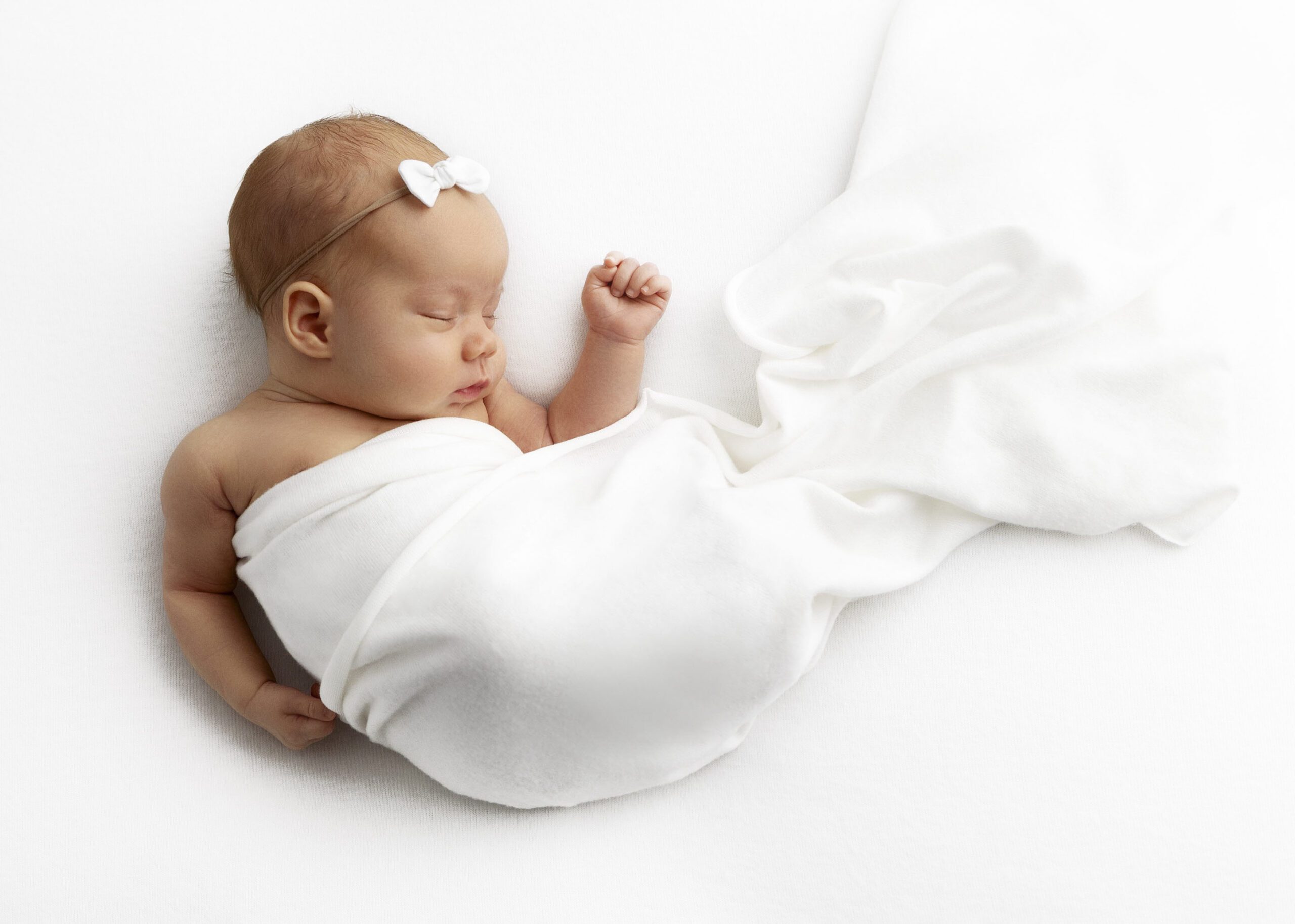 newborn girl wrapped in white blanket by DFW Newborn Photography