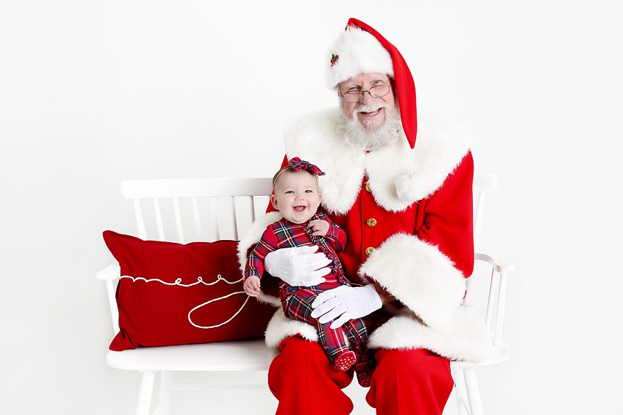 Baby girl and Santa sitting on a bench