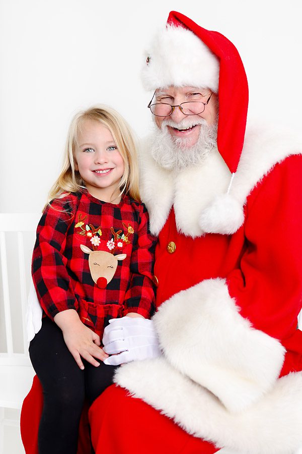 Little girl and Santa smiling at the camera for pictures with Santa Dallas, TX