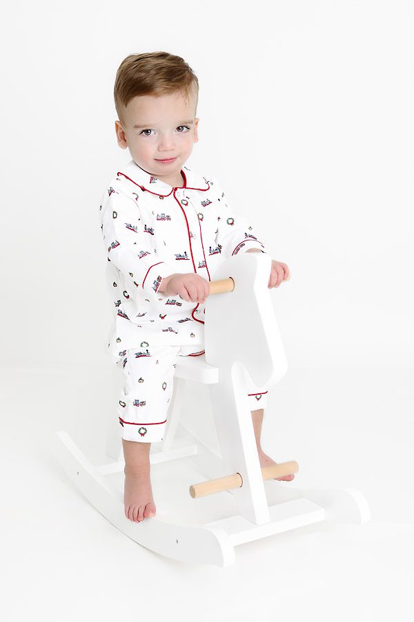 Little boy on a rocking horse in Christmas pajamas for pictures with Santa Dallas, TX
