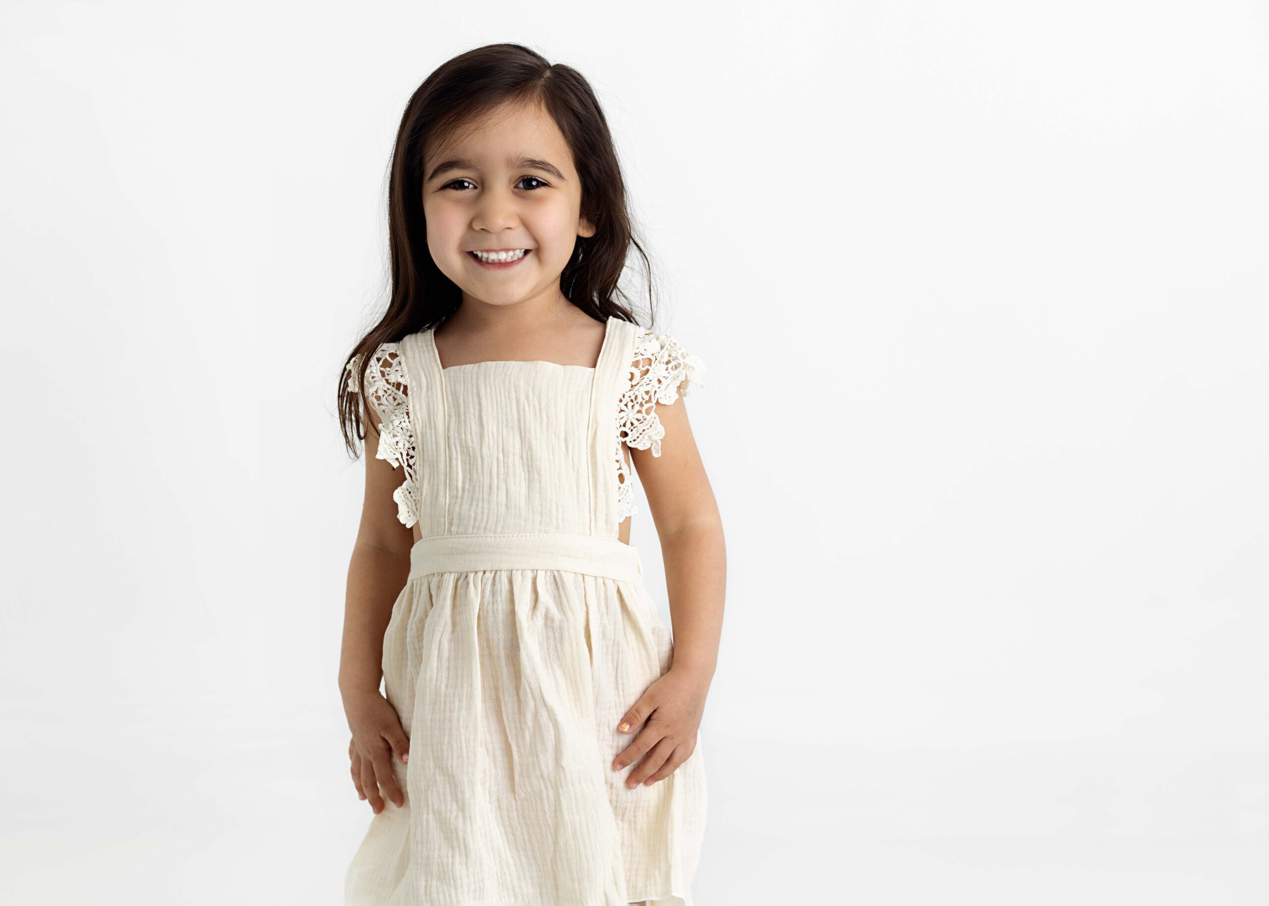 Little girl in white dress smiling for camera