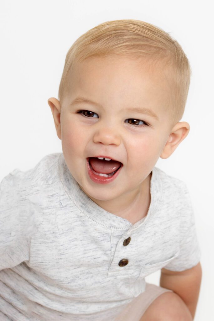 Toddler boy doubling over and smiling