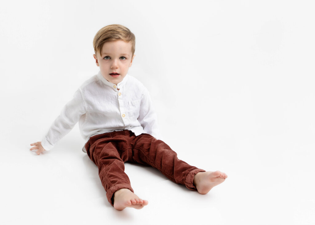 Little boy sitting with leg outstretched in front of him