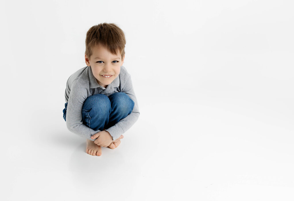 Little boy scrunched down into a ball