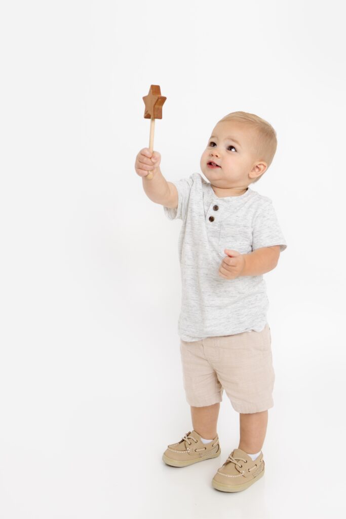 Little boy holding wand up and looking at it