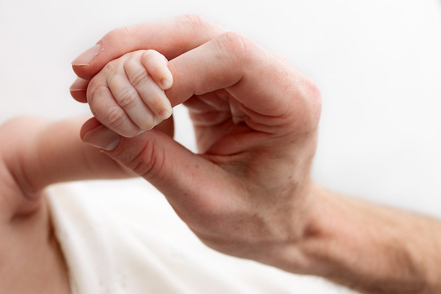 newborn holding father's fingers